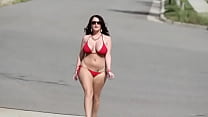 Sophie dee en bikini rojo camina por la carretera