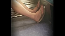 Открытые ноги в шлепанцах в поезде в Лондоне, Великобритания