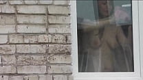 Nudo in pubblico. Nudo. All'aperto. Fuori. Il marito sexy Frina sta spiando sua sorella dal finestrino dell'auto quando lava la finestra dell'appartamento senza mutandine e reggiseno.